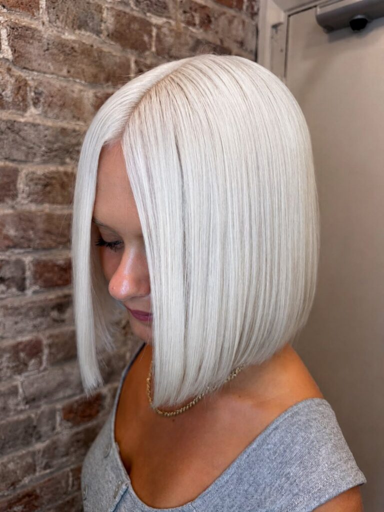 White-blonde bob with a sleek finish and deep side part