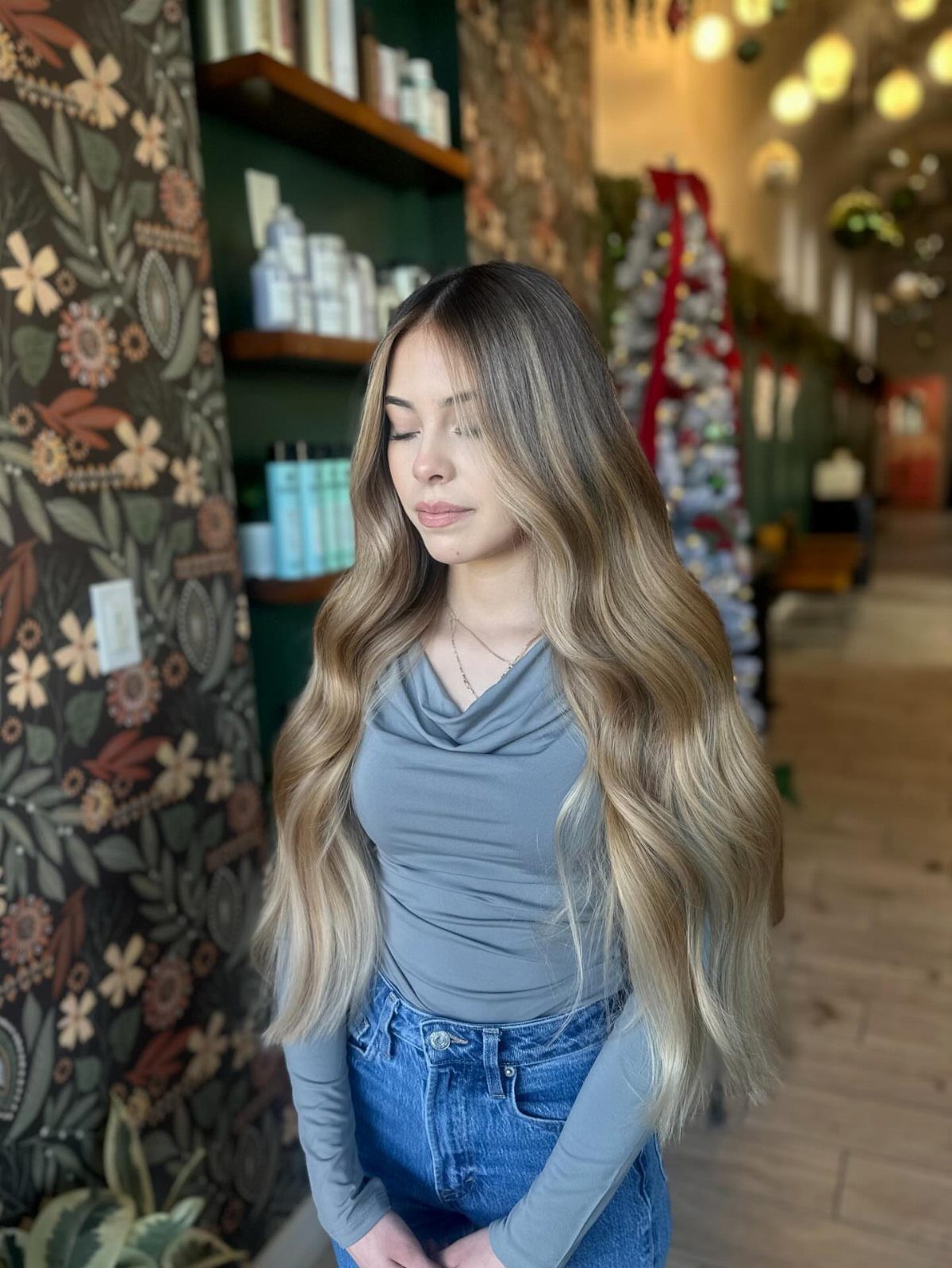 Woman with long, wavy beige blonde hair standing in a salon