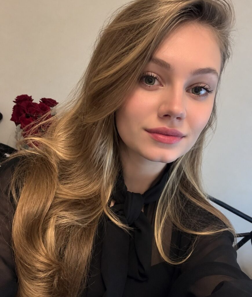 Woman with long blonde hair worn loose over a black top