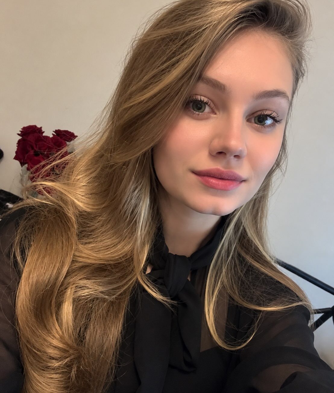 Woman with long blonde hair worn loose over a black top