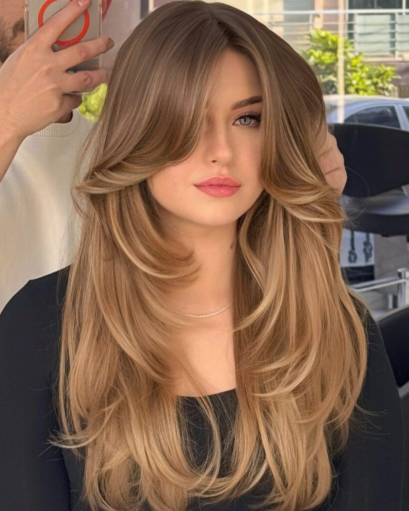 Woman with long, layered golden blonde hair in a salon