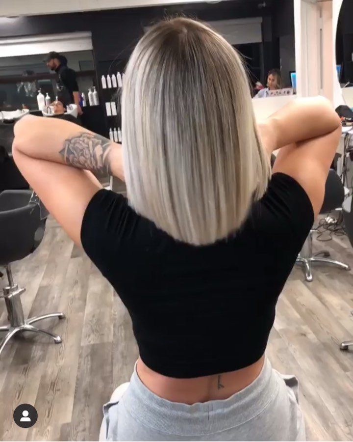 Woman displaying straight shoulder-length blonde hair in a salon
